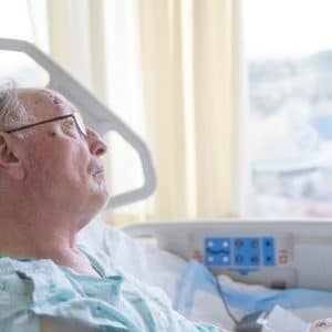 older man in hospital looking out window