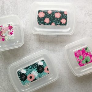 four containers with pretty floral degign on top and attached lids