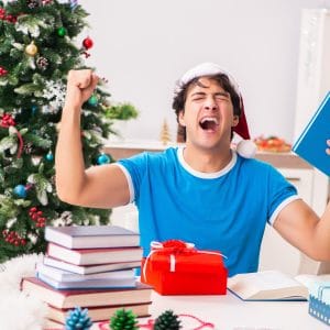 college student opening present in front of tree