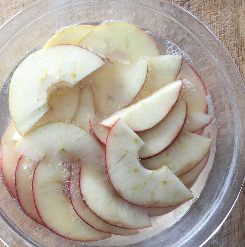 bowl of sliced apples and water