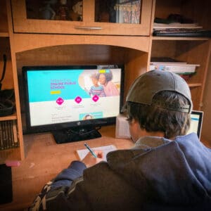 boy in front of computer doing virtual school