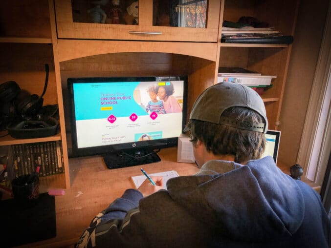 boy in front of computer doing virtual school