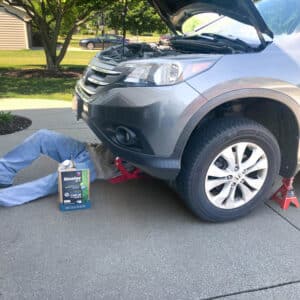 male under vehicle changing the oil