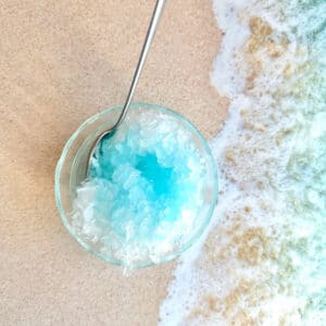 bowl of blue hawaiian shaved ice on a beach
