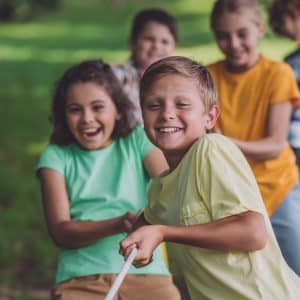 Selective focus of happy kids competing in tug of war