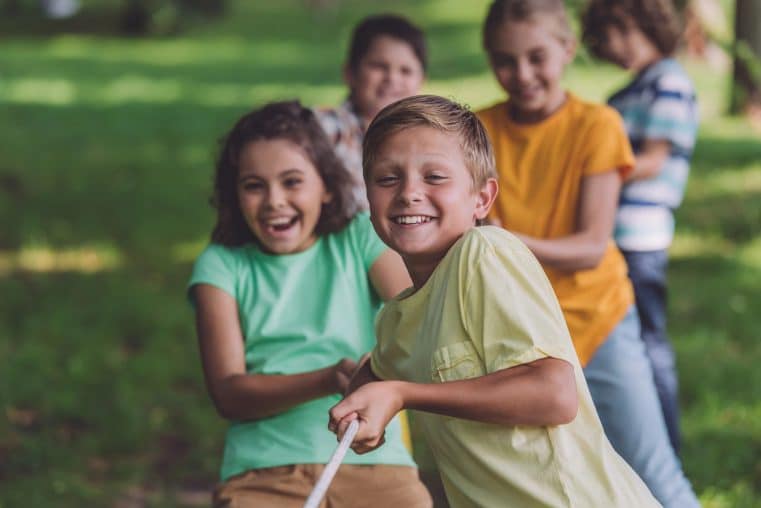 Selective focus of happy kids competing in tug of war