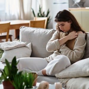 woman sitting on couch deep in thought