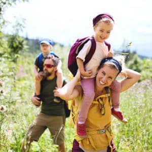 A family of four hiking through a meadow.