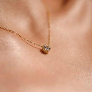 woman's neck wearing delicate diamond necklace