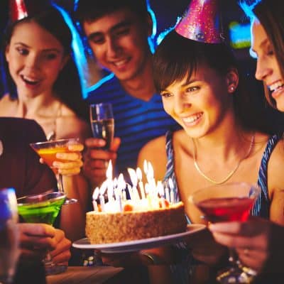 Female blowing on candles on birthday cake