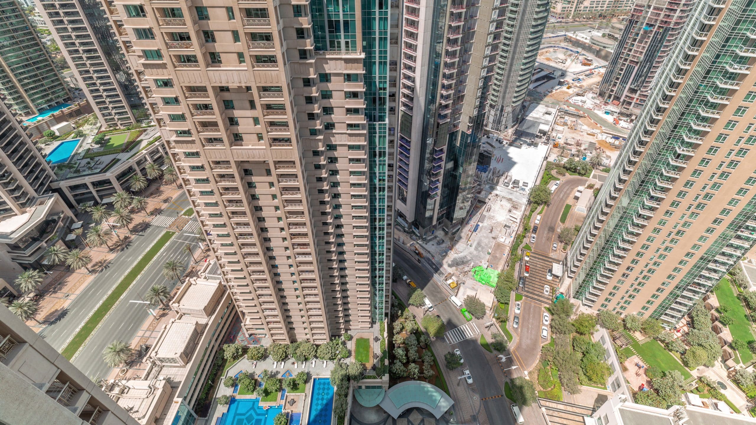 Aerial cityscape timelapse with modern architecture of Dubai downtown. Look down view to tall skyscrapers and towers with shadows moving fast. New construction site.
