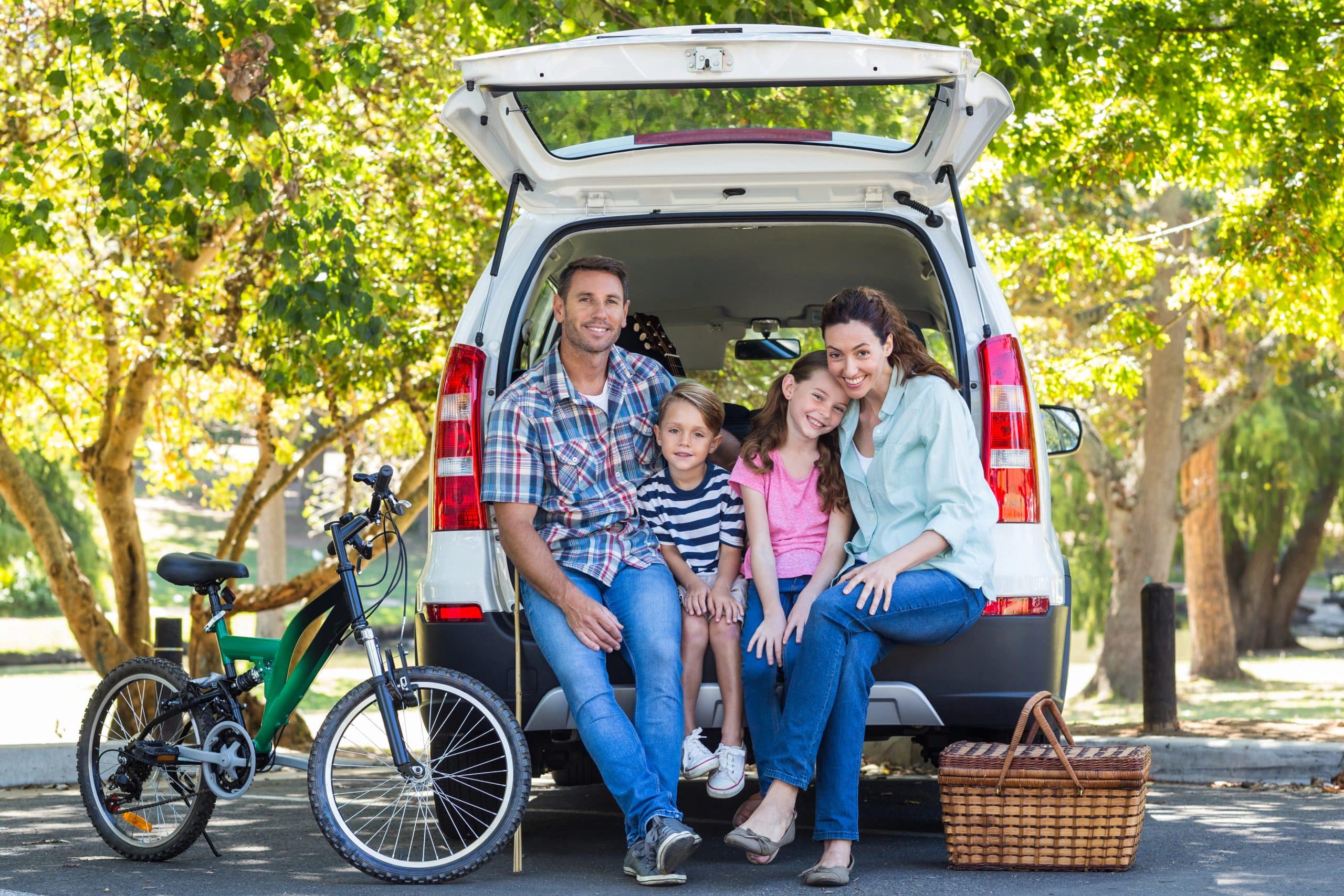 Family getting ready for road trip and sitting in the back of an SUV