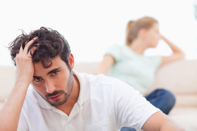 Sad couple mad at each other in living room