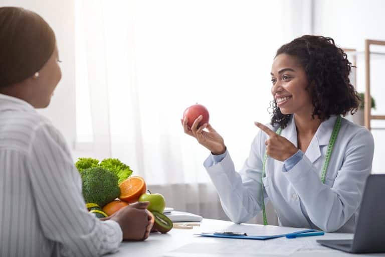Pretty nutritionist giving consultation to patient about healthy feeding
