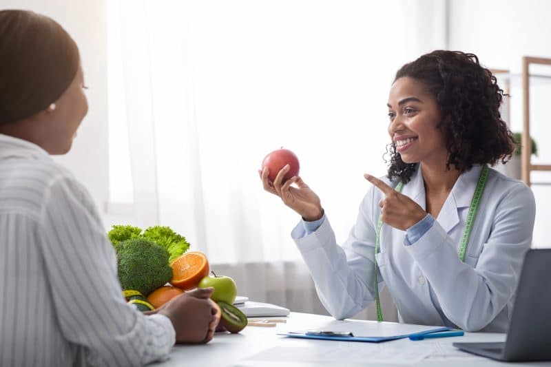 Pretty nutritionist giving consultation to patient about healthy feeding
