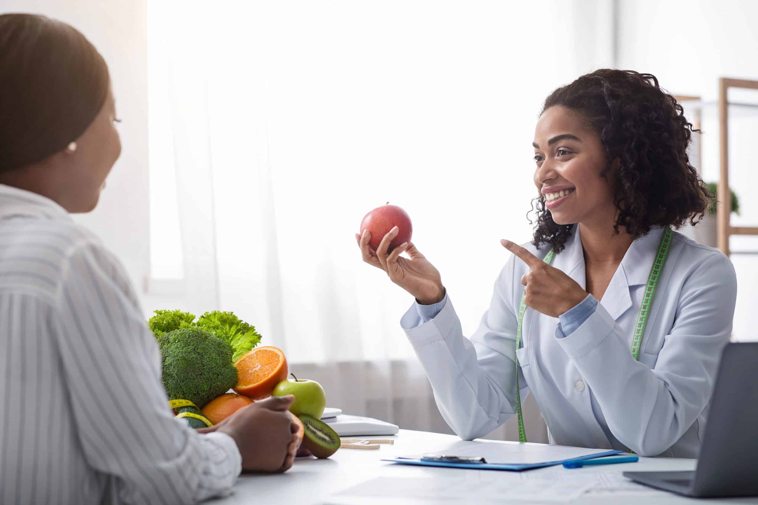 Pretty nutritionist giving consultation to patient about healthy feeding