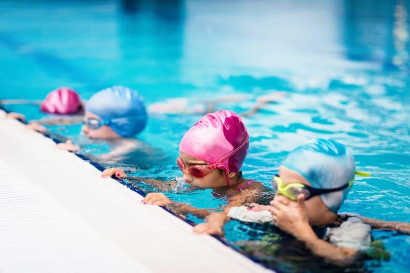 Group of children on swimming class, making bubbles