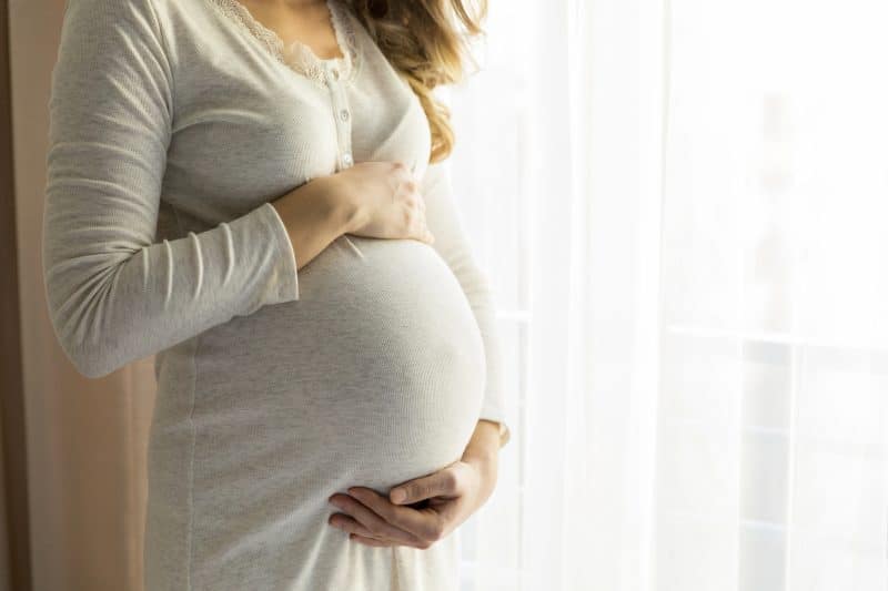 Young pregnant woman in bedroom