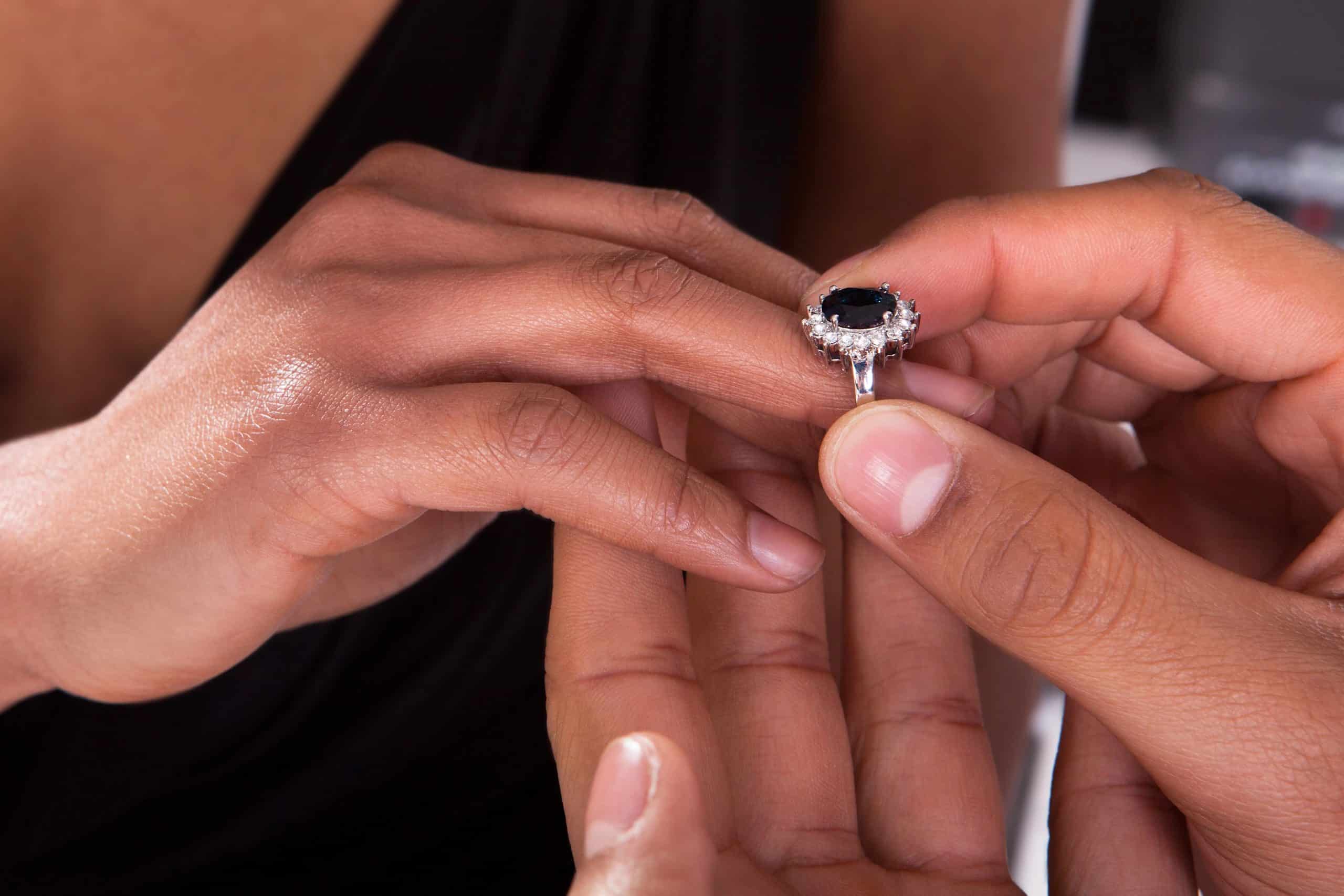 Male Hand Inserting Ring Into A Finger