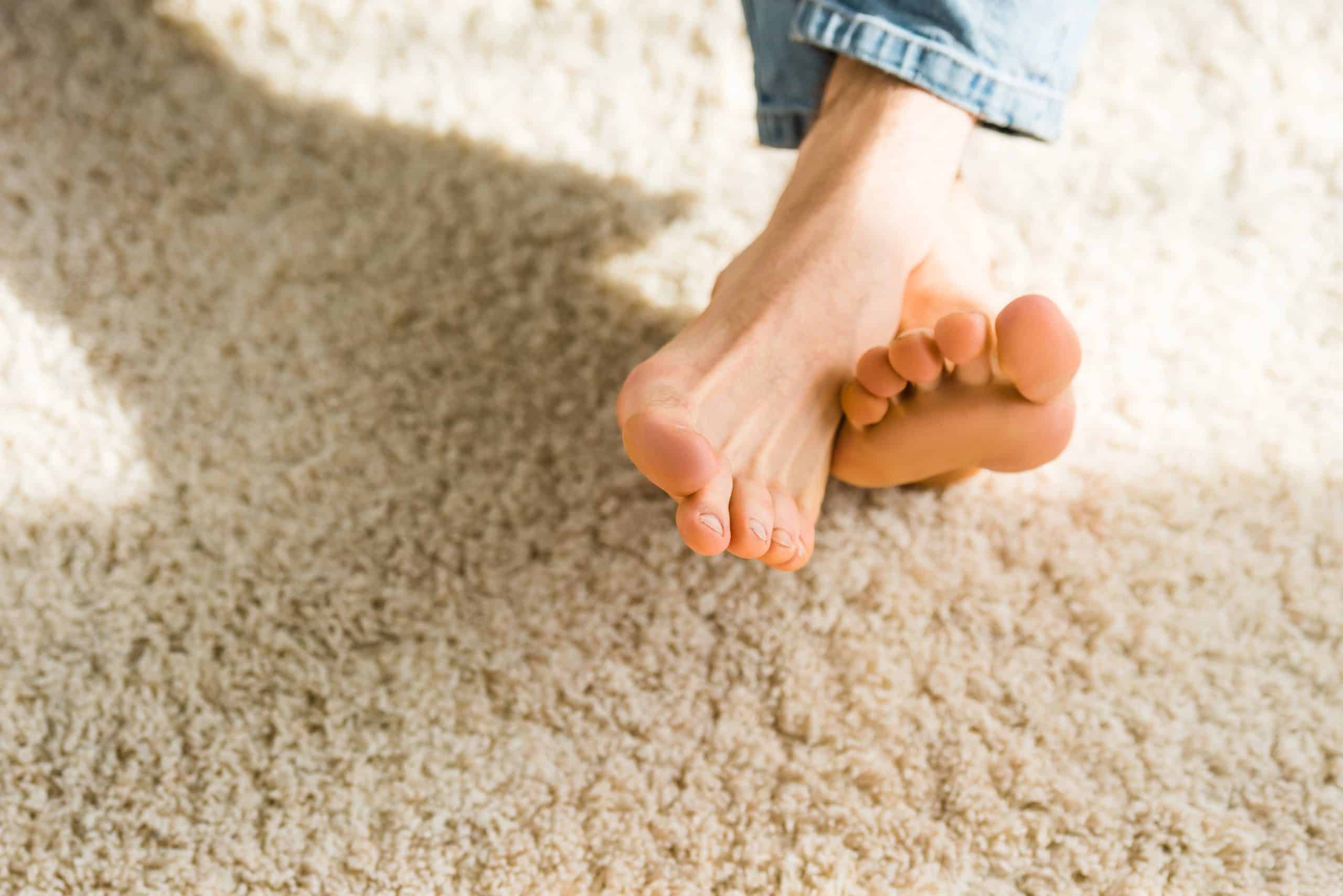 Cropped view of male feet on beige rug