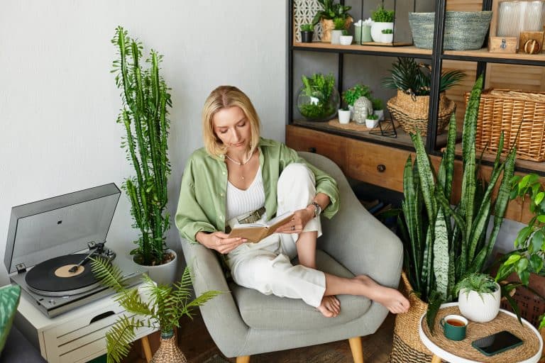 A beautiful adult woman relaxes in her cozy home, enjoying a peaceful moment as she reads a book.